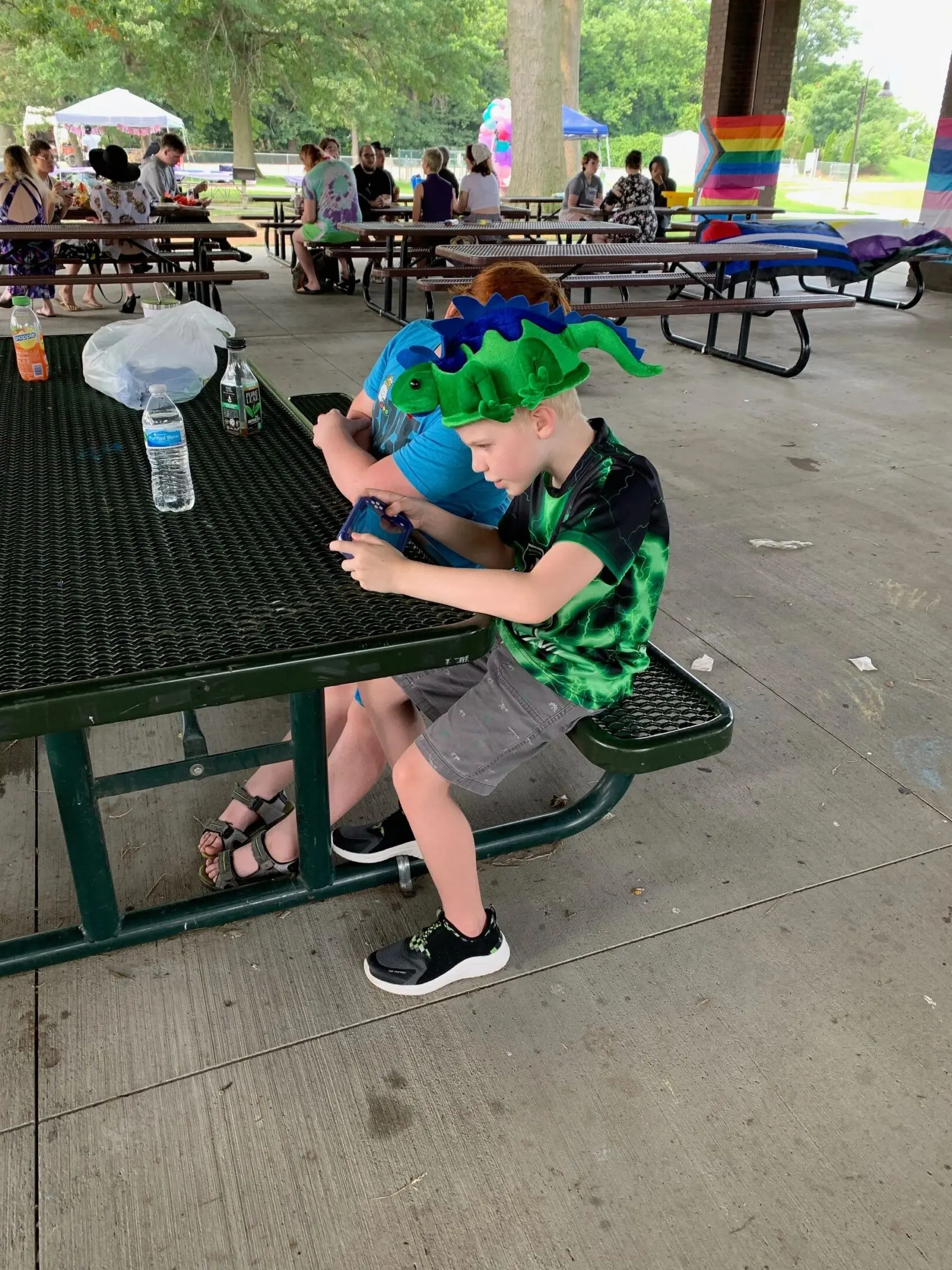 Boy in green shirt playing on phone