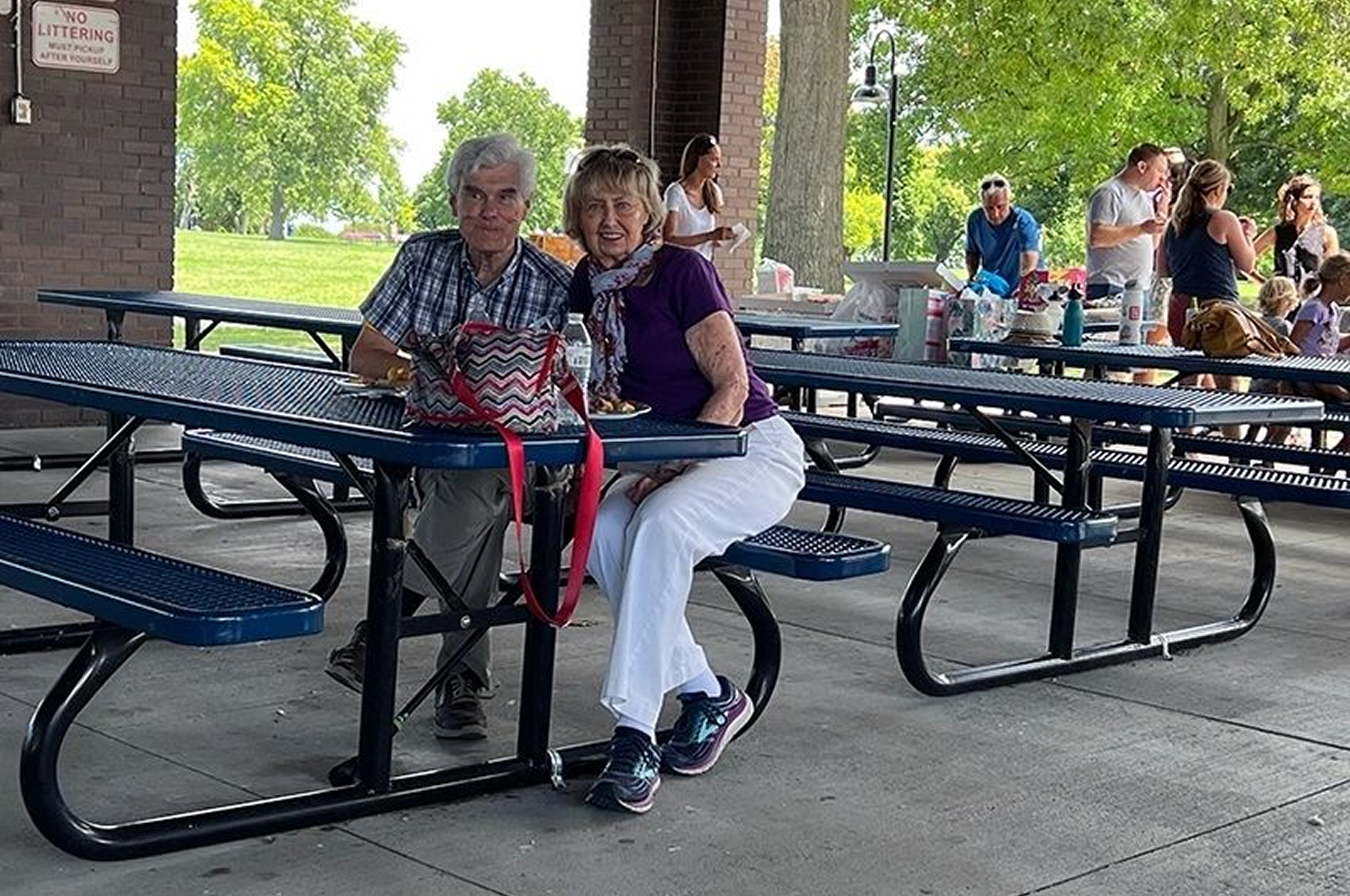 Elderly couple sitting at picnic table
