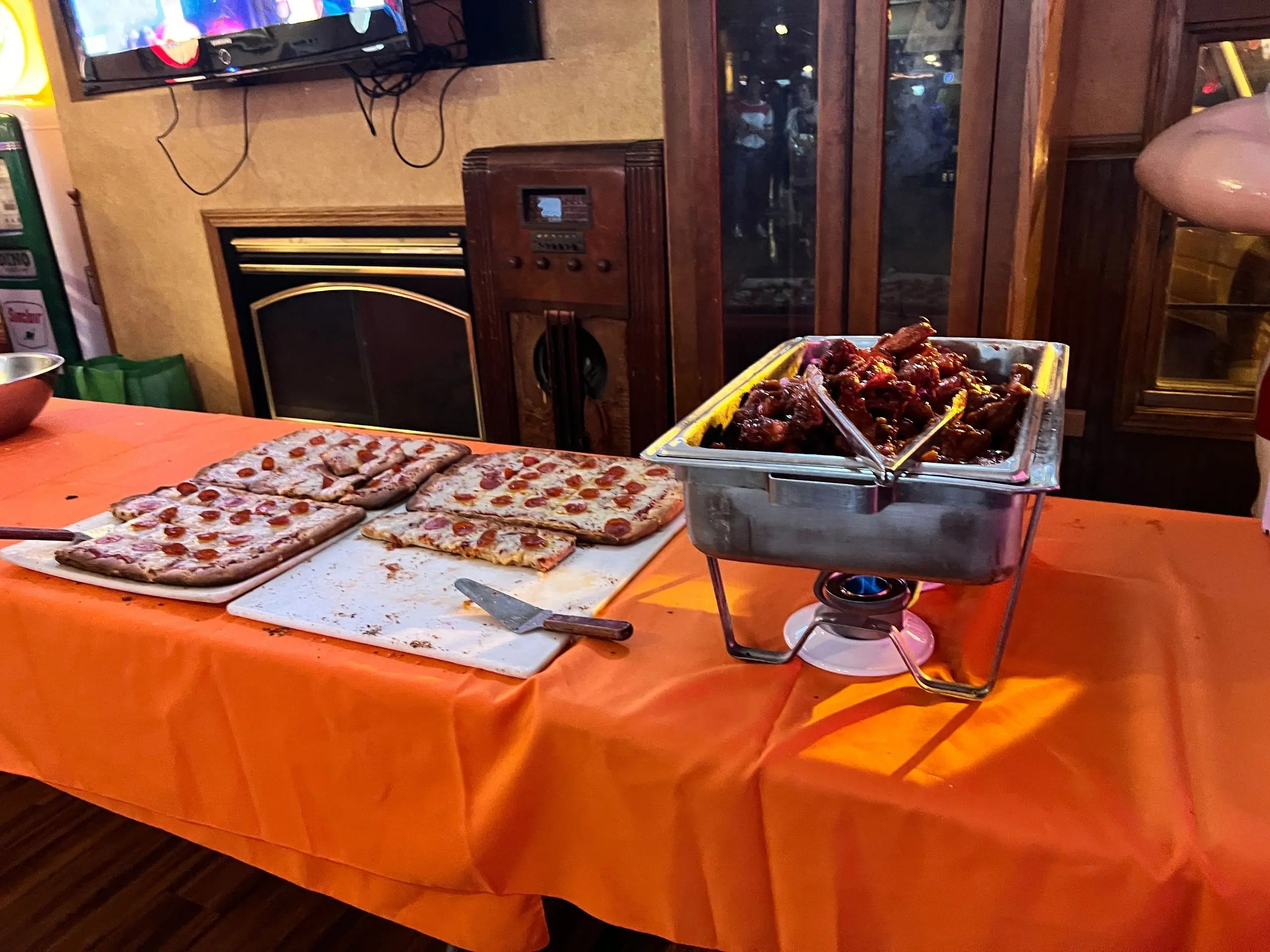 Buffet setup with pepperoni pizza and wings