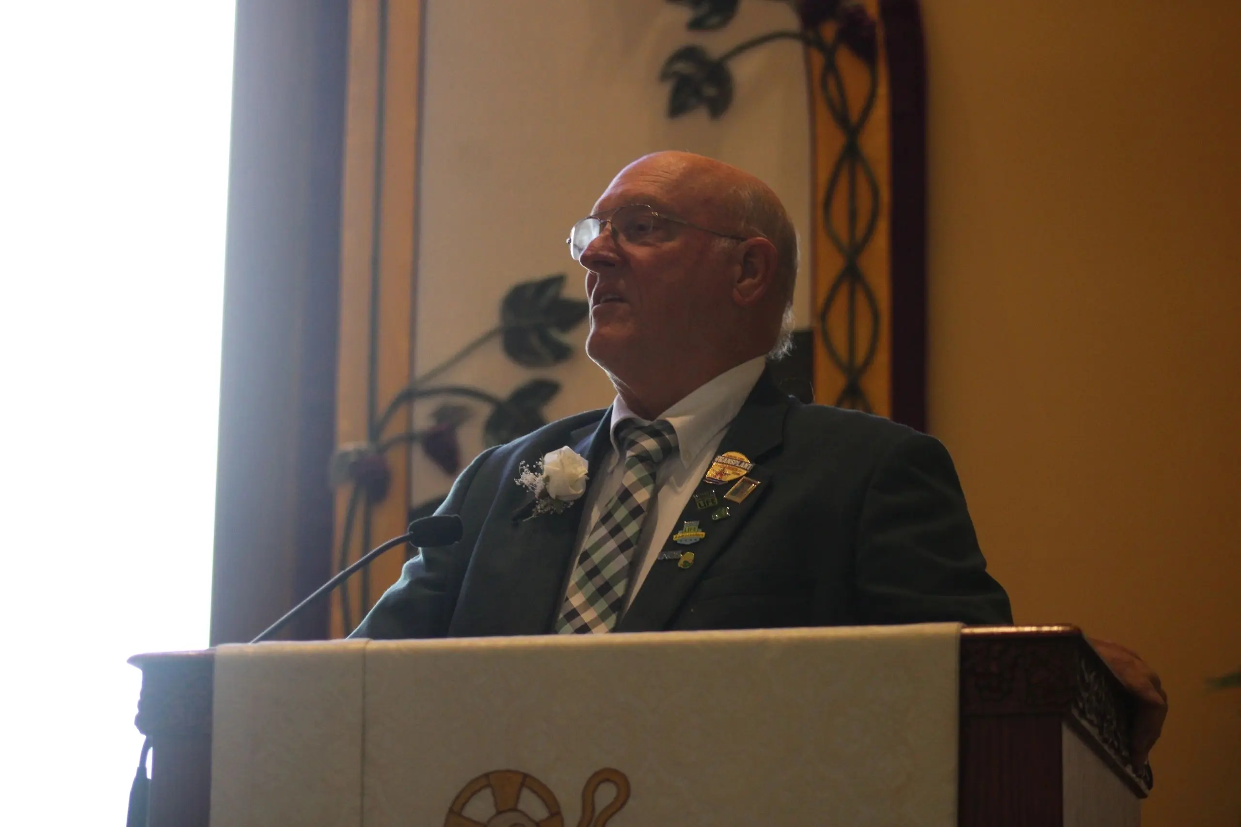 Elderly man giving a speech indoors